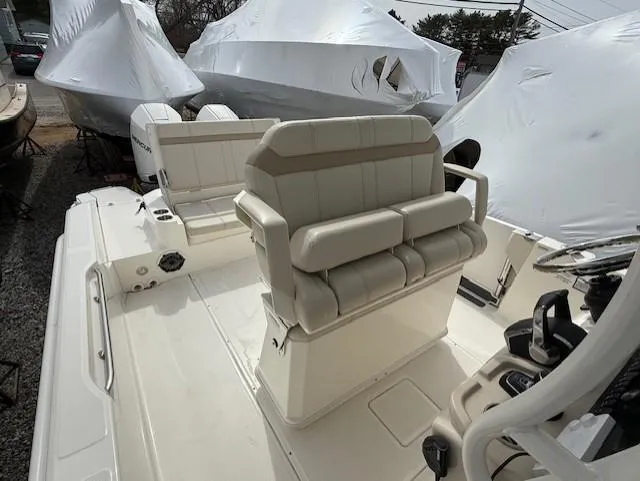 Slide: The Image of 2023 Boston Whaler 280 Dauntless boat interior with cushioned seating and helm station. - 10