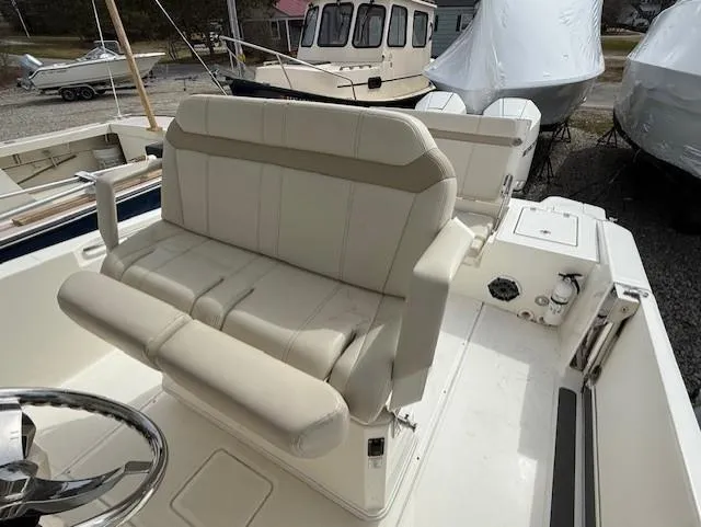 Slide: The Image of 2023 Boston Whaler 280 Dauntless boat interior with beige seating and steering wheel. - 11