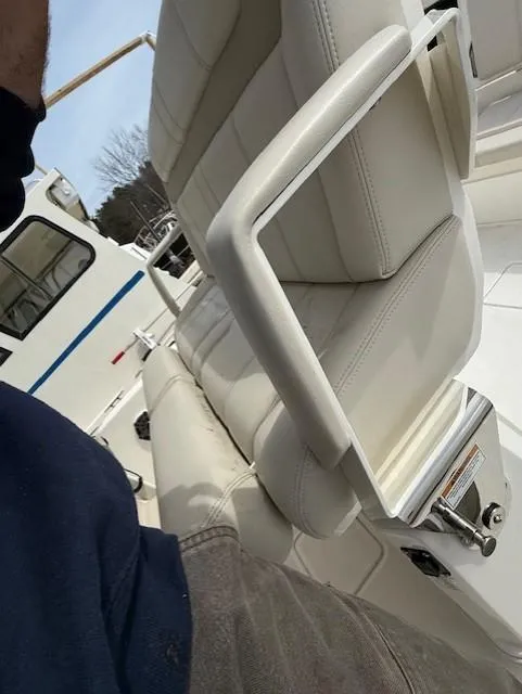 Slide: The Image of 2023 Boston Whaler 280 Dauntless boat interior with white seating and armrest detail. - 13