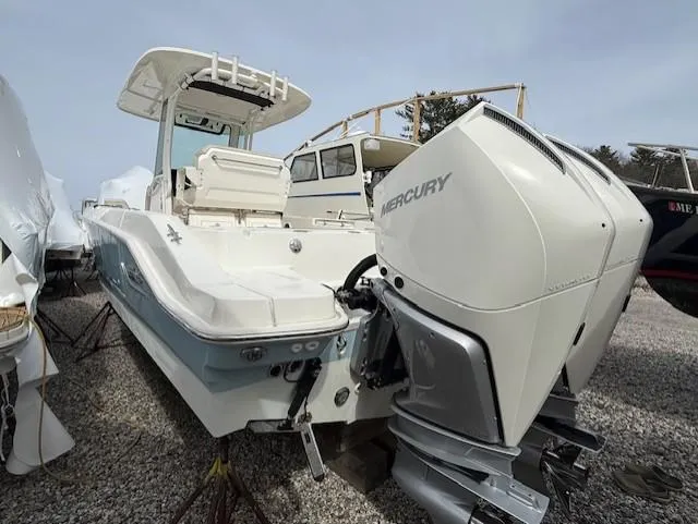 Slide: The Image of 2023 Boston Whaler 280 Dauntless boat with Mercury outboard engines, docked on gravel. - 16