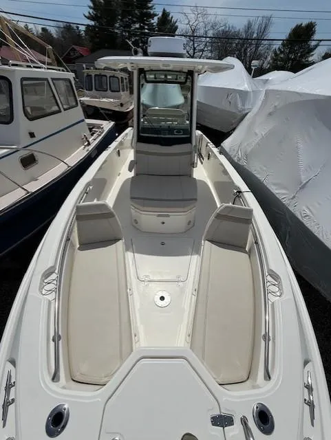 Slide: The Image of 2023 Boston Whaler 280 Dauntless boat with spacious deck and seating, docked outdoors. - 2