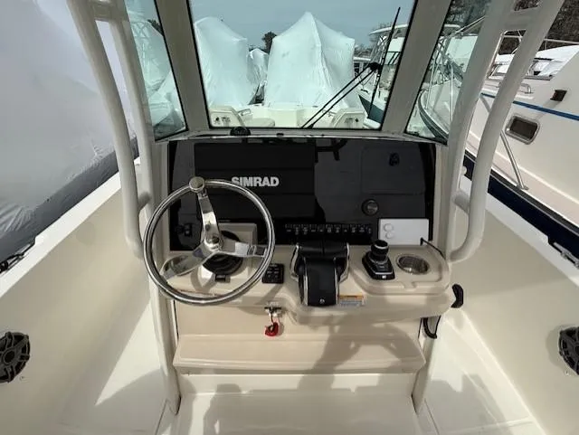 Slide: The Image of 2023 Boston Whaler 280 Dauntless helm with steering wheel and Simrad navigation system. - 9