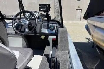 Slide: The Image of 2023 Smoker Craft Excursion 176 DC boat interior with steering wheel and dashboard controls. - 8