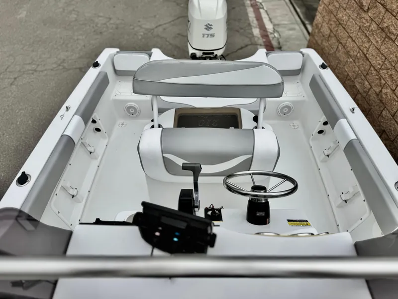 Slide: The Image of 2019 Caravelle Key Largo 2100 boat interior with steering wheel and seating, featuring Suzuki 175 engine. - 11