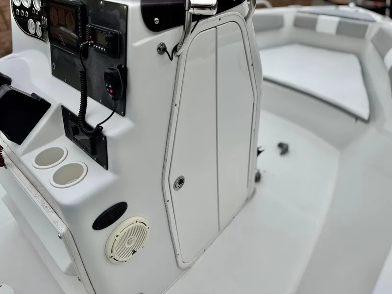 Slide: The Image of 2019 Caravelle Key Largo 2100 boat interior with control panel and seating area. - 19