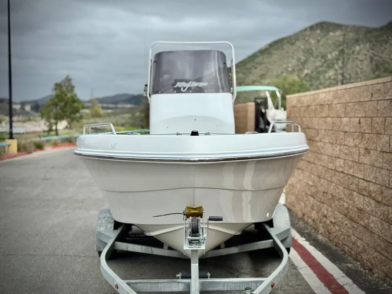 Slide: The Image of 2019 Caravelle Key Largo 2100 boat on trailer, parked near mountains. - 2