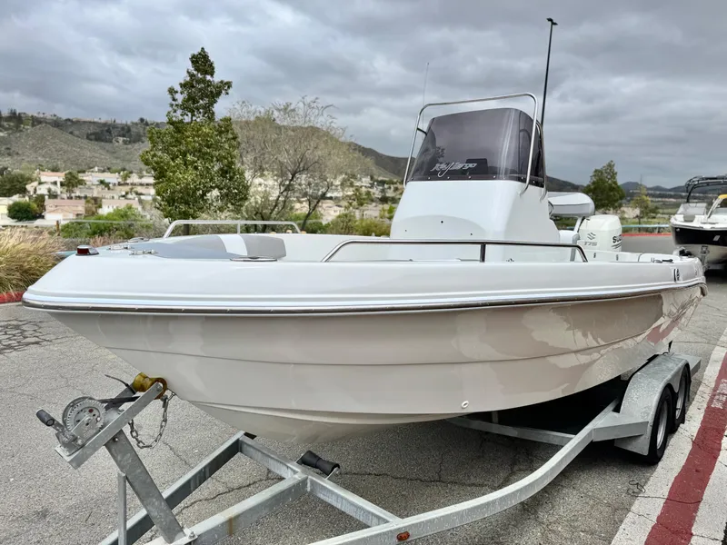 Slide: The Image of 2019 Caravelle Key Largo 2100 boat on trailer, parked outdoors under cloudy sky. - 3