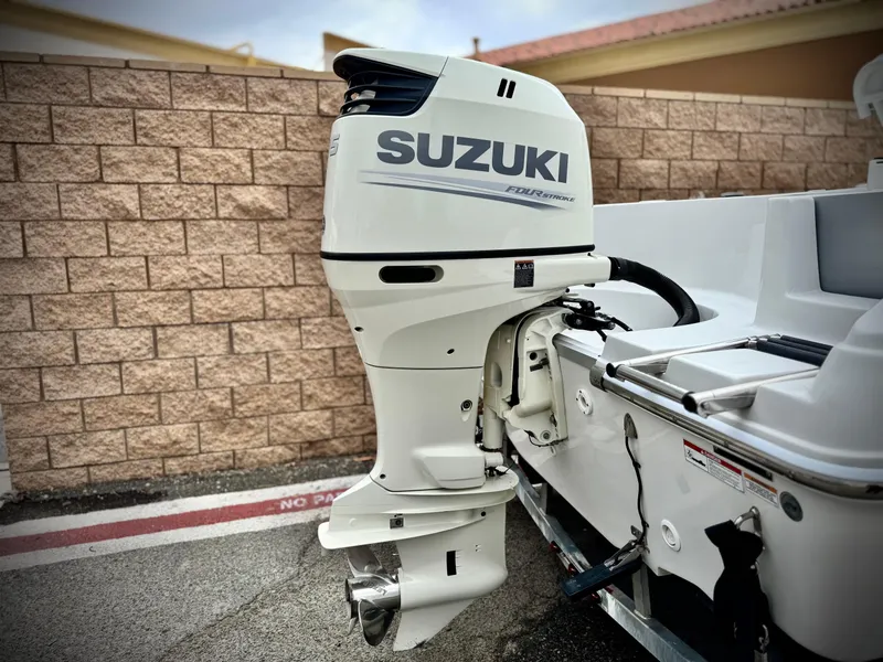 Slide: The Image of Suzuki outboard motor on 2019 Caravelle Key Largo 2100 boat, parked by a brick wall. - 6