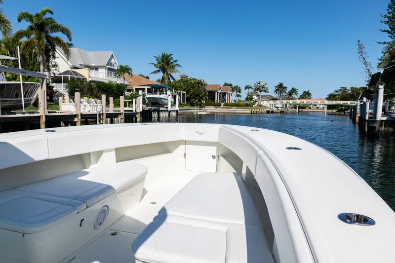 Slide: The Image of 2015 SeaVee 390Z boat on a sunny waterfront, showcasing spacious seating and sleek design. - 10