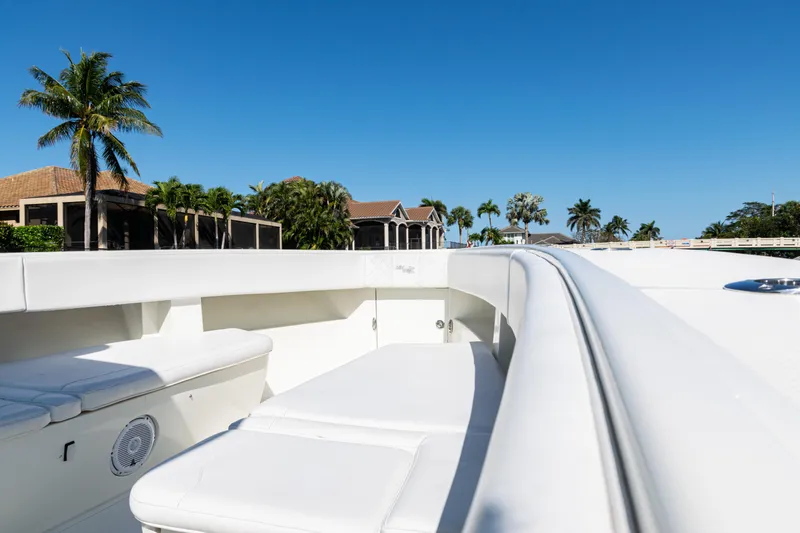 Slide: The Image of 2015 SeaVee 390Z boat deck with seating, set against a clear blue sky and palm trees. - 11