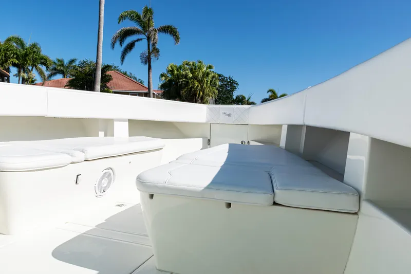 Slide: The Image of 2015 SeaVee 390Z boat interior with white seating, palm trees, and clear blue sky. - 15