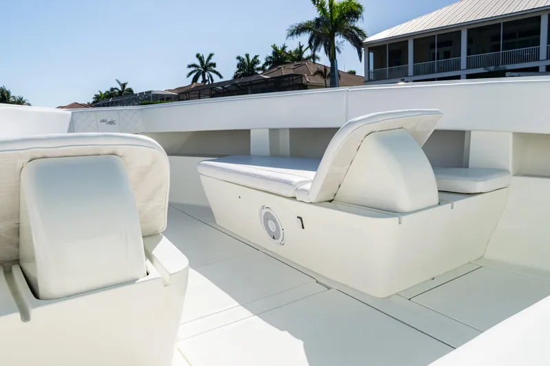 Slide: The Image of 2015 SeaVee 390Z boat interior with white seating and palm trees in the background. - 17