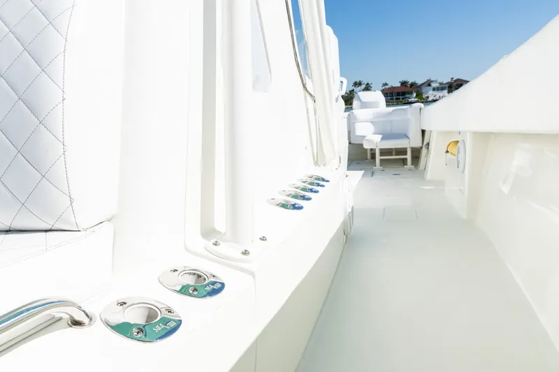 Slide: The Image of 2015 SeaVee 390Z boat deck with rod holders and seating, under clear blue sky. - 18