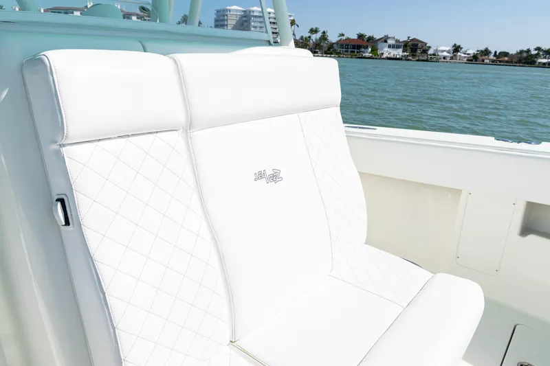 Slide: The Image of White leather seats on a 2015 SeaVee 390Z boat, with ocean and buildings in the background. - 22