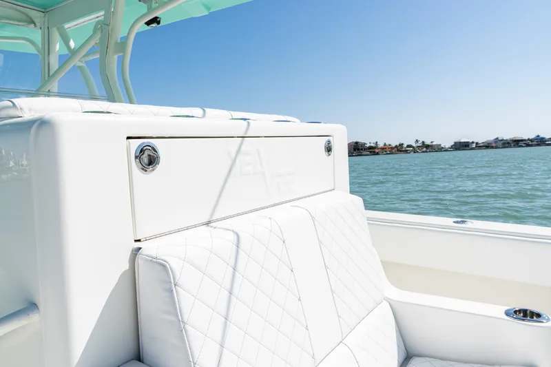 Slide: The Image of 2015 SeaVee 390Z boat interior with white cushioned seating, ocean view in background. - 32