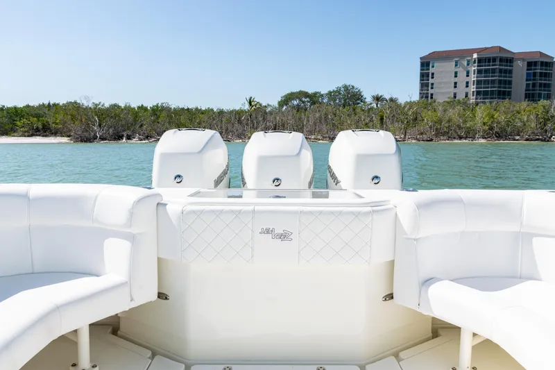 Slide: The Image of 2015 SeaVee 390Z boat with quad engines, white seating, and coastal backdrop. - 38