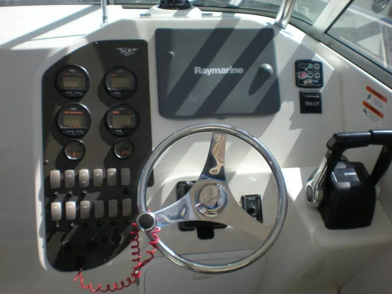 Slide: The Image of 2006 Seaswirl Striper boat dashboard with steering wheel and Raymarine navigation system. - 10