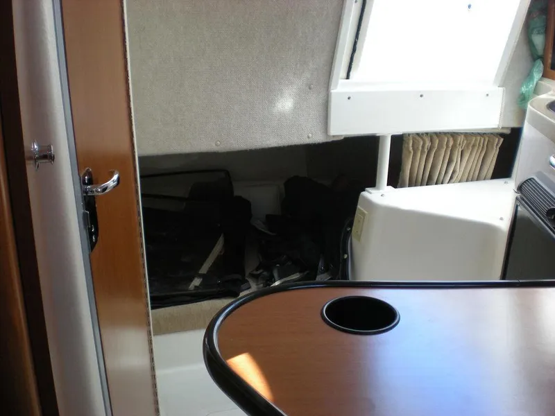 Slide: The Image of Interior of a 2006 Seaswirl Striper boat, featuring a cabin with a table and storage area. - 17