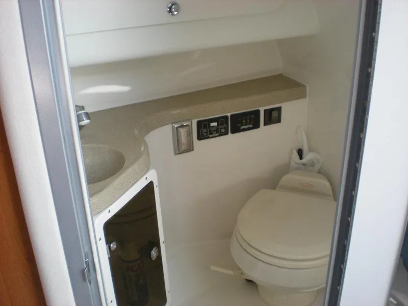 Slide: The Image of 2006 Seaswirl Striper boat bathroom with sink, toilet, and control panel. - 18
