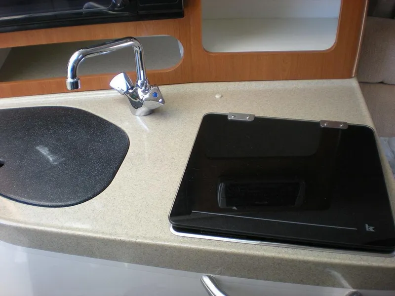 Slide: The Image of 2006 Seaswirl Striper boat interior with sink and stove in compact kitchen area. - 22