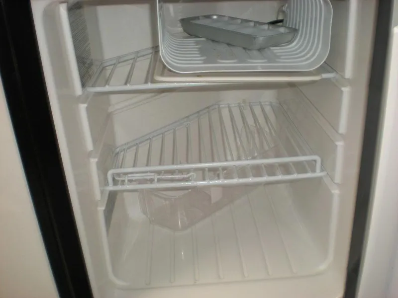 Slide: The Image of Empty refrigerator interior with wire shelves in a 2006 Seaswirl Striper boat. - 25