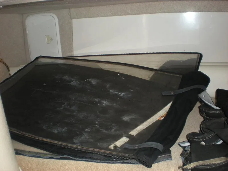 Slide: The Image of 2006 Seaswirl Striper interior storage compartment with black cover and equipment. - 26
