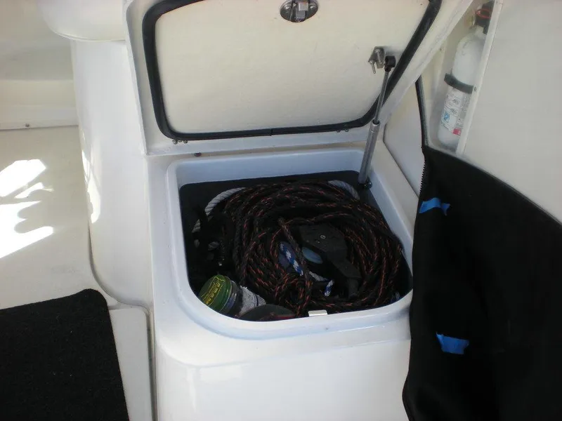 Slide: The Image of Storage compartment on a 2006 Seaswirl Striper boat, containing coiled rope and equipment. - 9