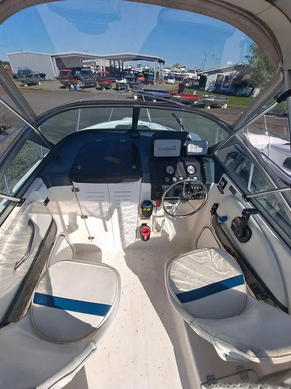 Slide: The Image of 1998 Bayliner 2052 boat interior with steering wheel, dashboard, and seating. - 2