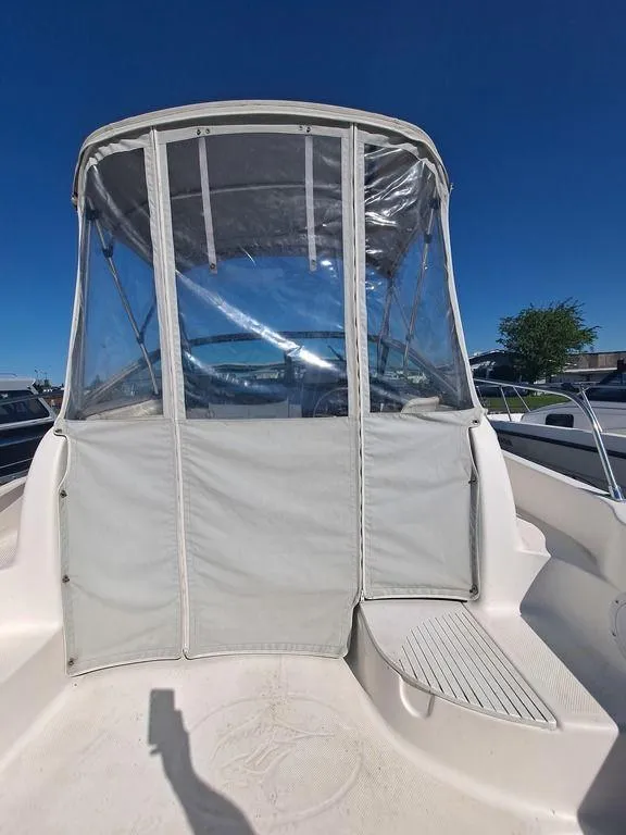 Slide: The Image of 1998 Bayliner 2052 boat with clear canopy under a bright blue sky. - 3