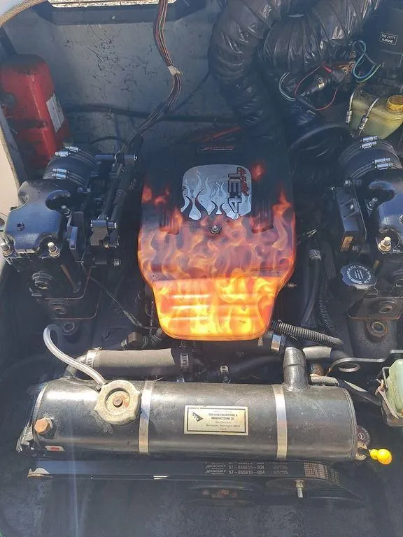 Slide: The Image of 1998 Bayliner 2052 engine with flame design cover, detailed view. - 5