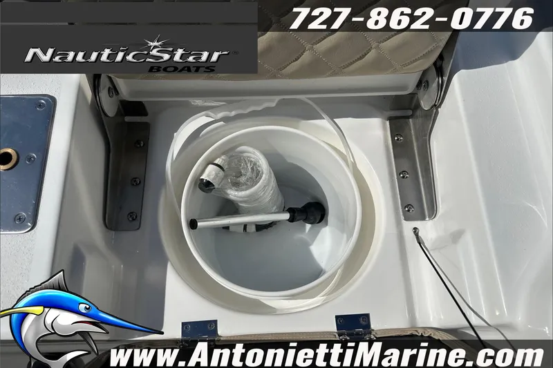 Slide: The Image of 2025 NauticStar 194 Bay boat interior with storage compartment and fishing gear. - 19