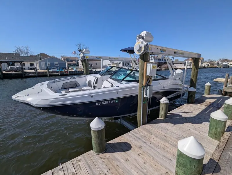 Slide: The Image of 2023 Monterey M-65 boat docked at a marina, clear sky, calm water. - 0
