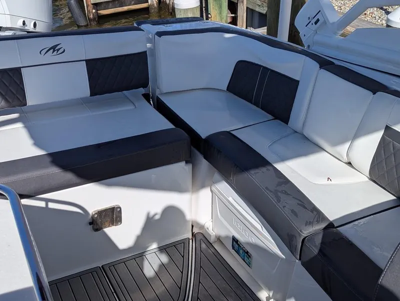 Slide: The Image of 2023 Monterey M-65 boat interior with cushioned seating and sleek design. - 11