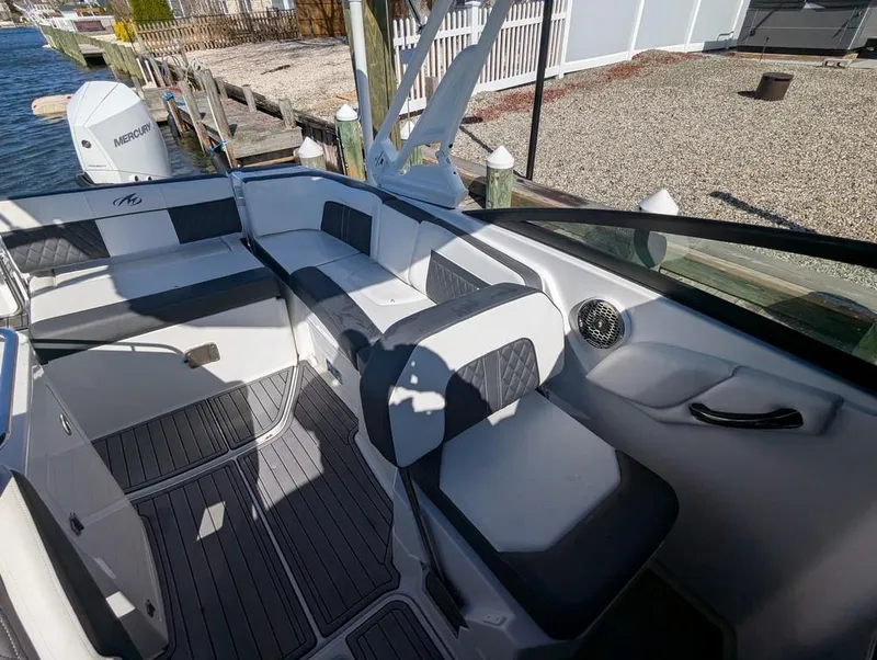 Slide: The Image of 2023 Monterey M-65 boat interior with cushioned seating and sleek design. - 18