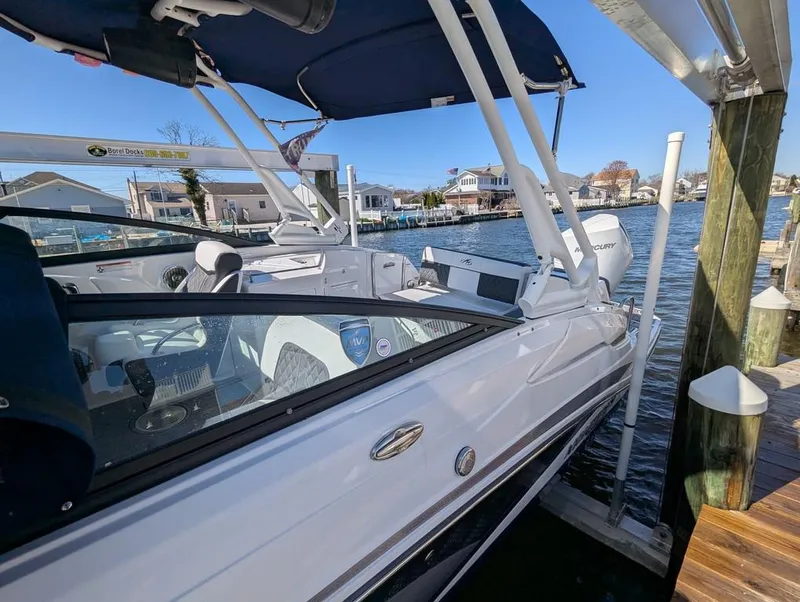 Slide: The Image of 2023 Monterey M-65 boat docked by waterfront homes under clear blue sky. - 23