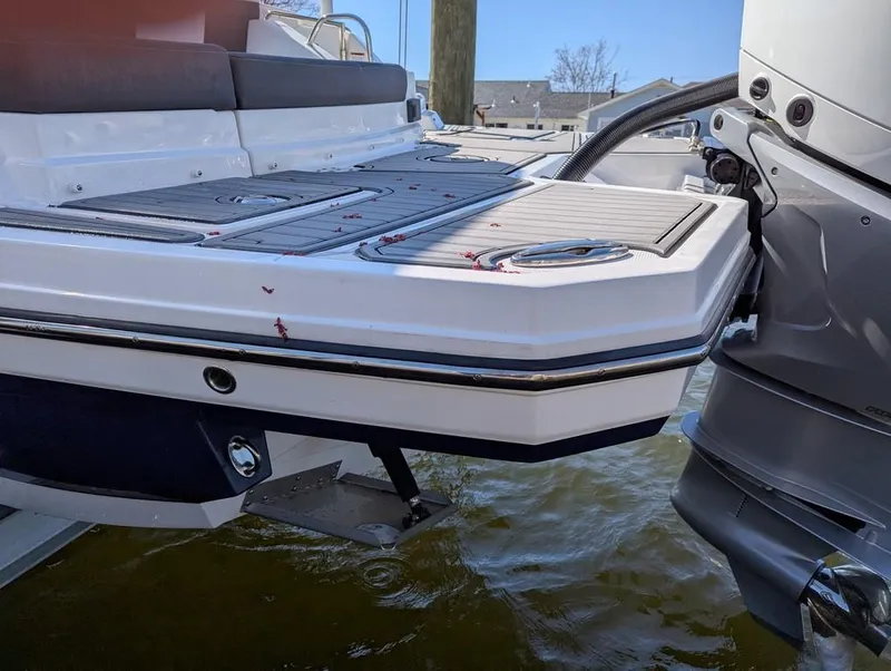 Slide: The Image of 2023 Monterey M-65 boat stern with outboard motor, docked on water. - 29