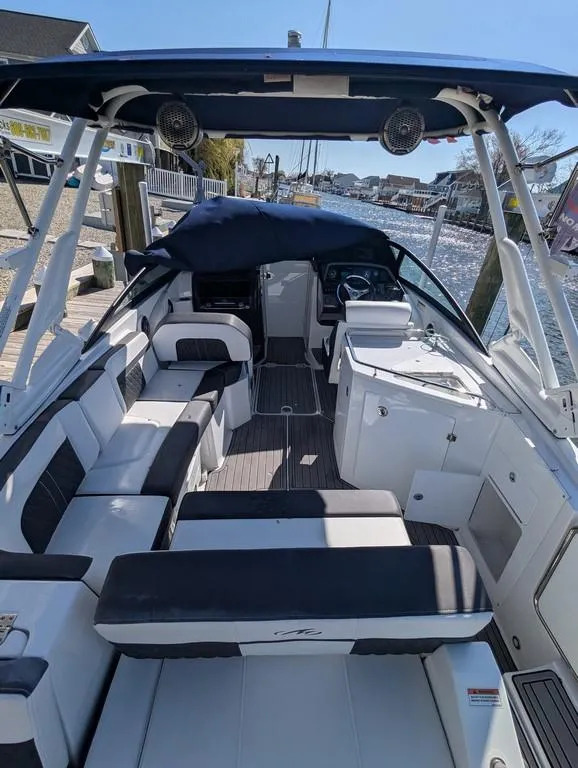 Slide: The Image of 2023 Monterey M-65 boat with spacious seating and sleek design docked by the water. - 34
