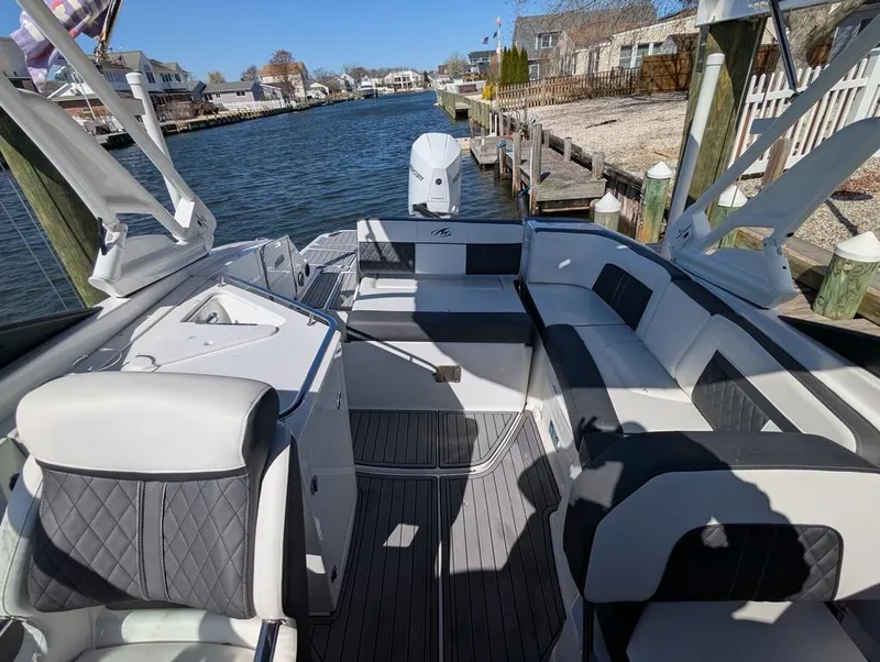Slide: The Image of 2023 Monterey M-65 boat interior with luxurious seating, docked by a scenic waterfront. - 35
