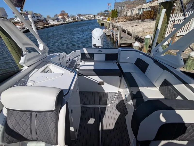 Slide: The Image of 2023 Monterey M-65 boat with spacious seating, docked by a scenic waterfront. - 36