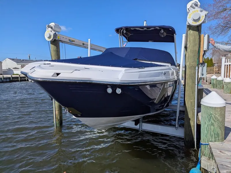 Slide: The Image of 2023 Monterey M-65 boat on lift, covered and docked by the water. - 5