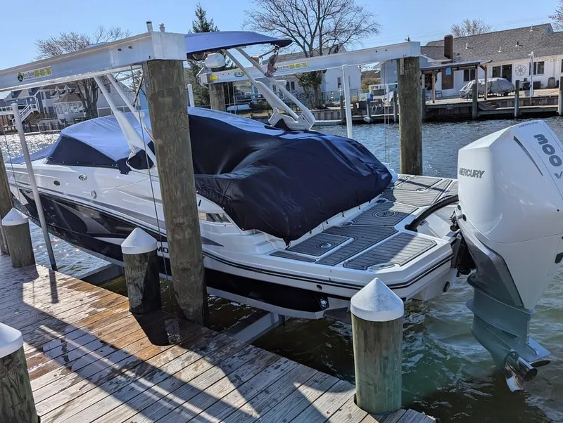 Slide: The Image of 2023 Monterey M-65 boat docked with cover, featuring Mercury outboard motor. - 9