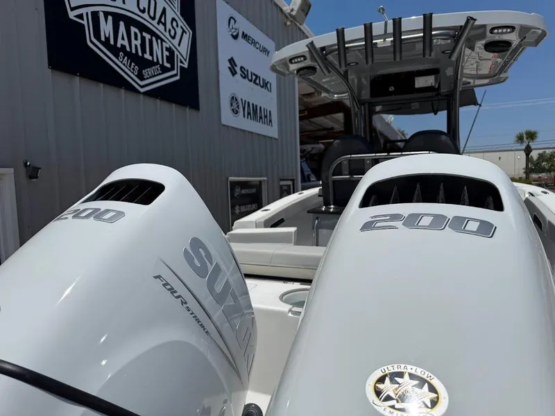 Slide: The Image of 2025 Sea Pro 262 Offshore boat with dual Suzuki 200 engines at a marine dealership. - 10