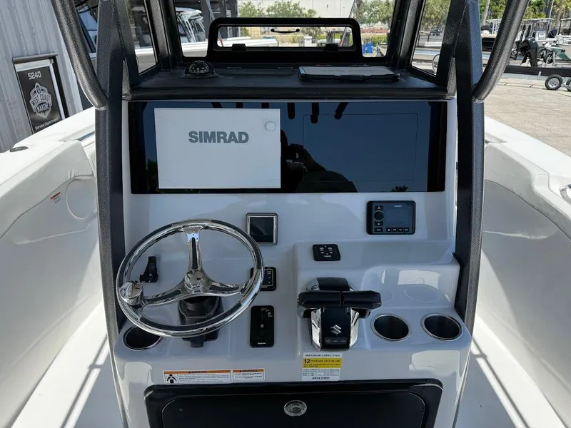 Slide: The Image of 2025 Sea Pro 262 Offshore boat console with Simrad display and steering wheel. - 12