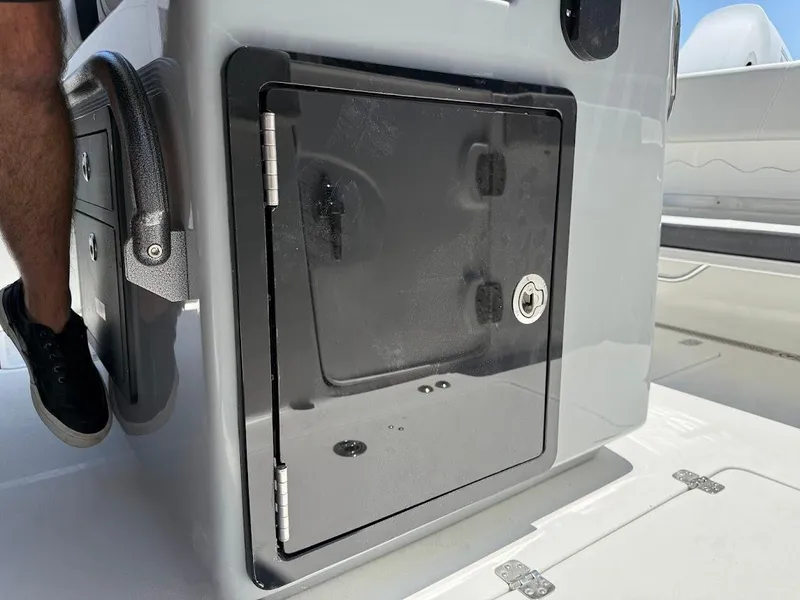 Slide: The Image of 2025 Sea Pro 262 Offshore boat storage compartment with secure lock and sleek design. - 21