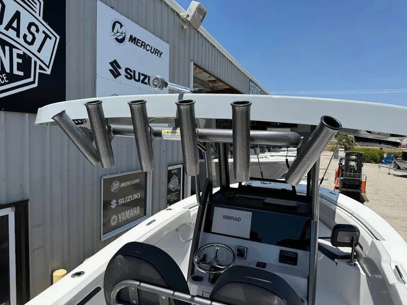Slide: The Image of 2025 Sea Pro 262 Offshore boat at dealership, featuring rod holders and console. - 29