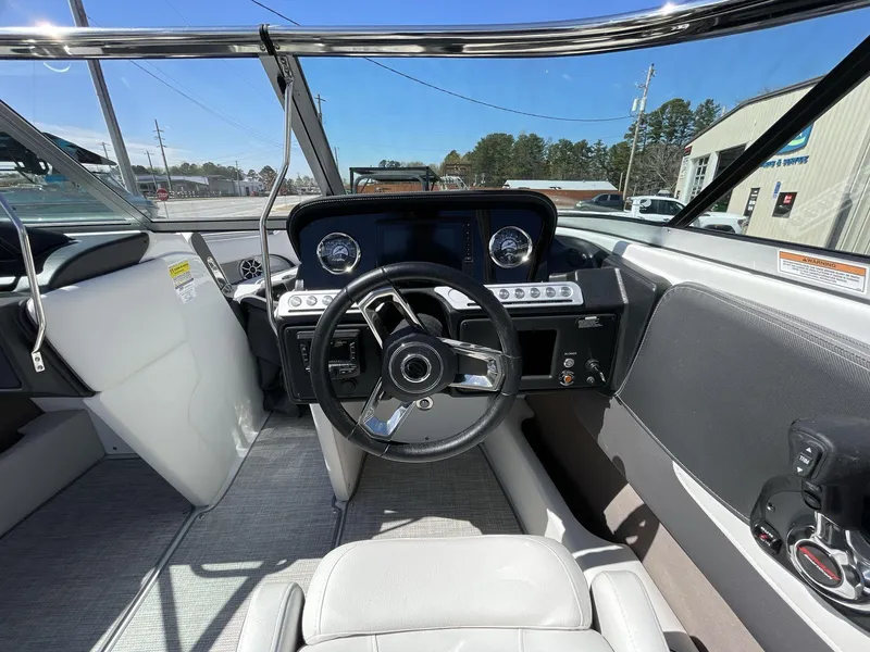Slide: The Image of Interior view of 2023 Crownline 240 SS boat cockpit with steering wheel and dashboard. - 10