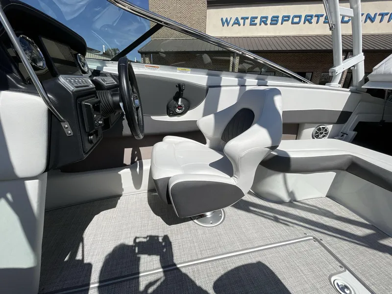 Slide: The Image of 2023 Crownline 240 SS boat interior with modern seating and steering wheel. - 11
