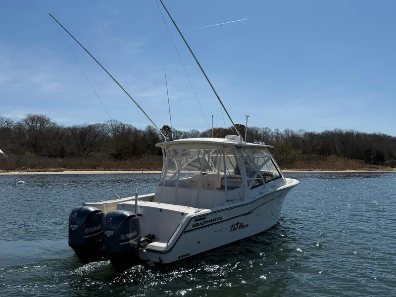 Slide: The Image of 2015 Grady-White Freedom 335 boat on water with dual engines, clear sky background. - 2