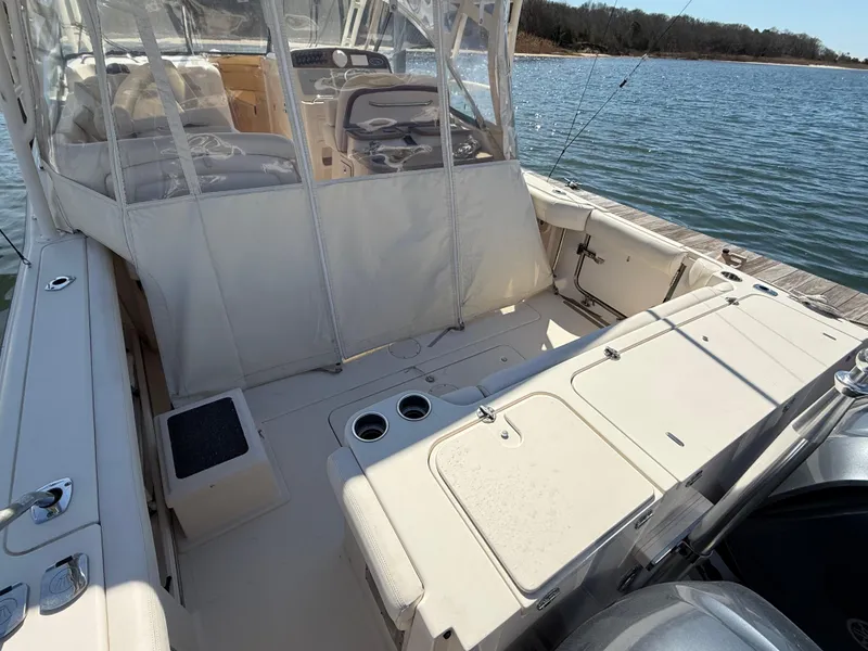 Slide: The Image of 2015 Grady-White Freedom 335 boat interior with seating and fishing setup on the water. - 7