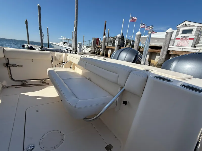 Slide: The Image of 2015 Grady-White Freedom 335 boat interior with seating, docked by the water. - 9